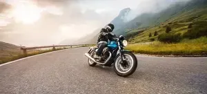 fisheye foto van een motorrijder op een blauwe motor in een bocht