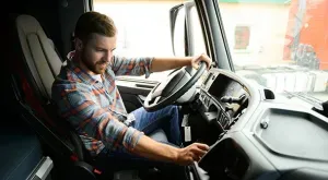 vrachtwagenchauffeur bedient iets op het dashboard van zijn vrachtwagen