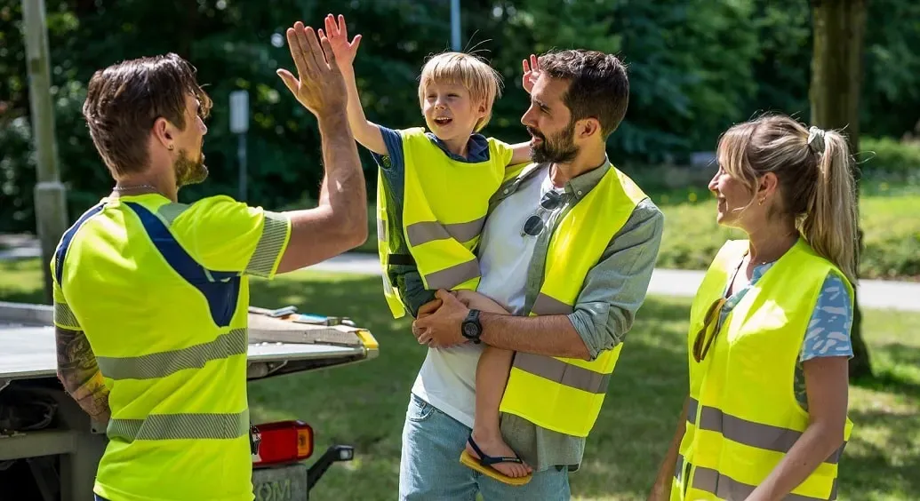 kleine jongen op arm van papa geeft een high five aan een VAB-wegenwachter