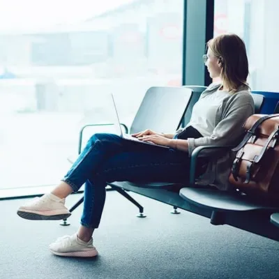 vrouw kijkt uit het raam van een terminal in een luchthaven