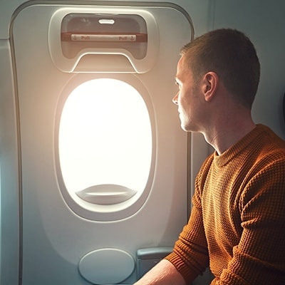 man kijkt uit het raam van een vliegtuig