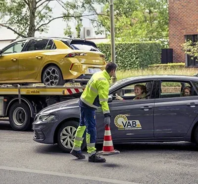 een vab-wegenwachter plaatst een oranje kegel naast een auto