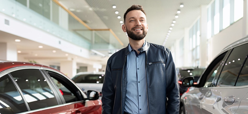 jonge man in showroom met auto's