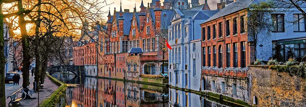 huizen langs het water in Brugge bij een winterse zonsondergang