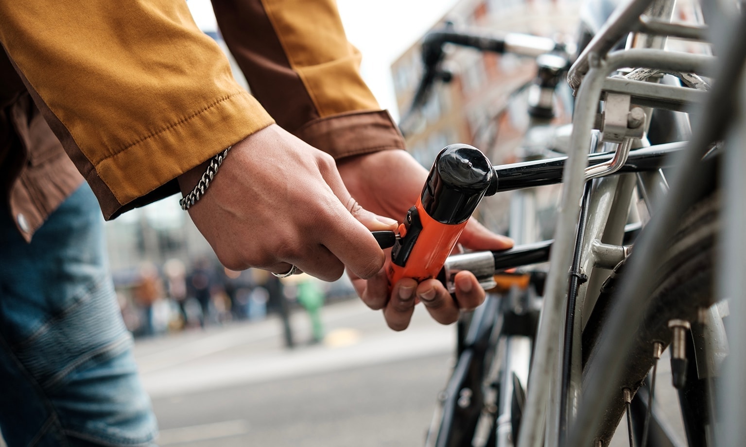 Handen sluiten een fietsslot aan een fiets vast op straat.